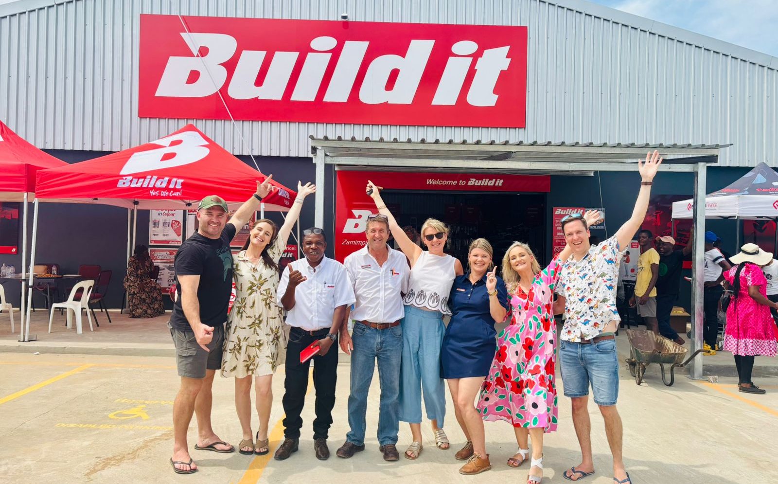 Several people standing in front of a Build It store